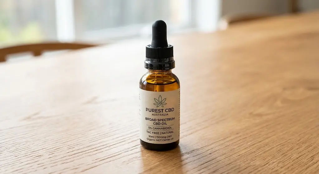 Dropper bottle of Broad Spectrum CBD Guide oil on a clean wooden table